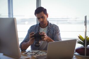 Photographer with camera working in ofice